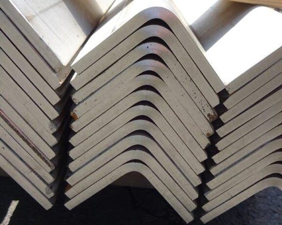 A close-up view of stacked 317L stainless steel angles, highlighting sharp bends and clean edges, formed in-house.