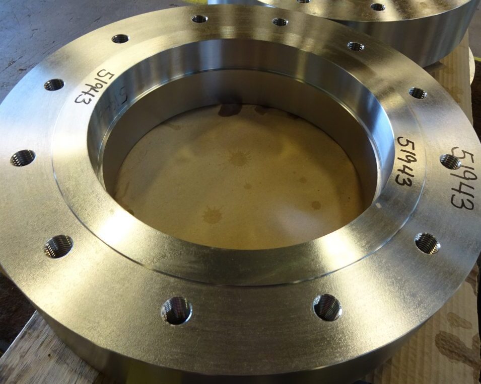 Close-up of a precision-machined 316L stainless steel ring with a raised face, featuring 16 evenly spaced drilled and tapped holes. The custom-made part, created for a pressure vessel manufacturer, showcases Sandmeyer Steel Company's high-precision machining capabilities.