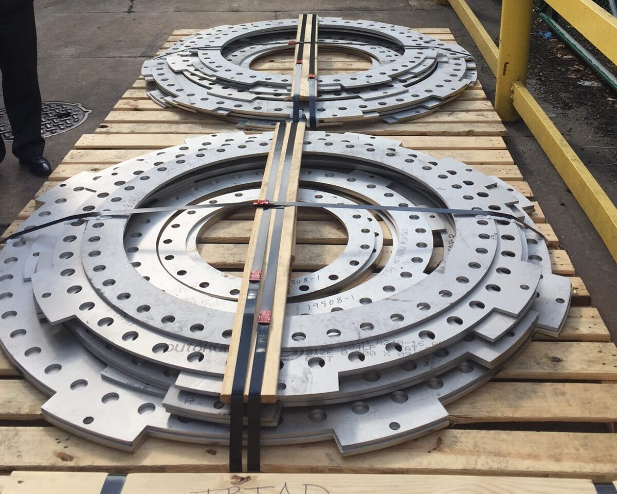 Two large, precision-cut stainless steel components made from 1/2” thick Alloy 304, placed on a pallet for delivery. The pieces were custom-made for a manufacturer of expansion joints.