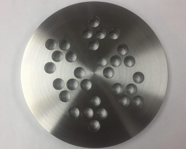 Precision-machined stainless steel tubesheet with multiple drilled holes, produced by Sandmeyer Steel Company using the Quickmill Annihilator machine.