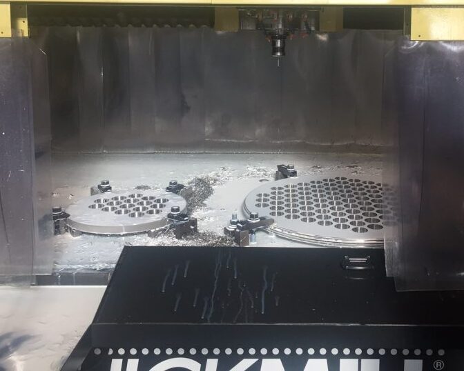 Sandmeyer Steel Company employee overseeing the QuickMill Annihilator machine drilling precision tubesheets with multiple holes for a processing equipment manufacturer.