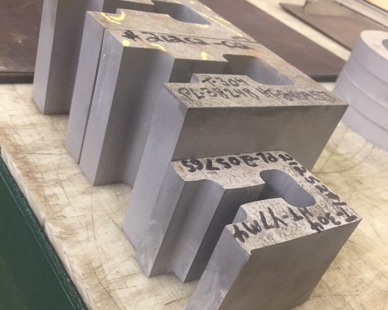 Precision-cut stainless steel blocks made from 5” thick 304L, produced by Sandmeyer Steel for a customer specializing in industrial pipe support systems using a waterjet machining center.