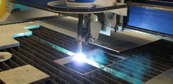 Plasma cutting equipment cutting stainless steel plate on a CNC cutting table.